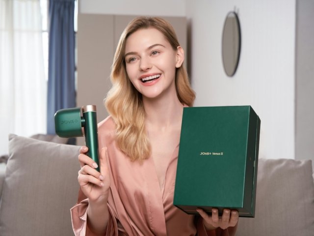 a woman holding a hair dryer and a box